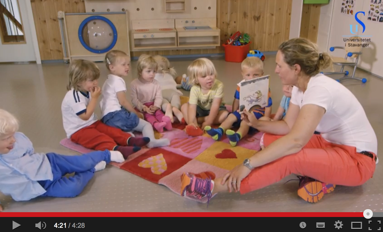 Stillbilde fra film. Lesestund med barnehagelærer og barn.