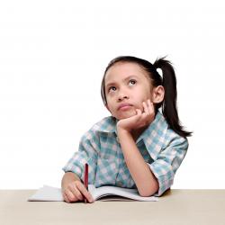 Elev ser opp, og ser ut som hun tenker mens hun holder en penn og har en oppslått skrivebok foran seg